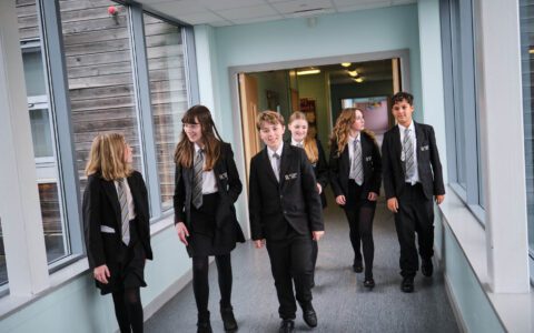 students in uniform walking down the corridor